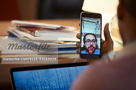 Businessman video chatting with colleague on smart phone