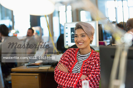 Smiling, confident creative businesswoman working in office