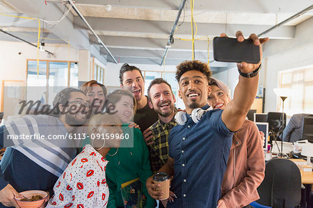 Creative business team taking selfie in office