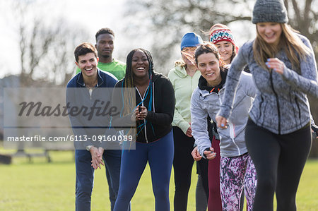 Team cheering woman running in park