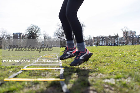 Woman using exercising ladder in park