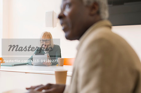 Senior businesswoman using digital tablet in conference room meeting