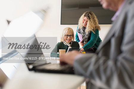 Businesswomen using digital tablet in conference room meeting