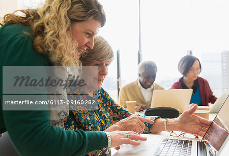 Businesswomen using laptop in conference room meeting
