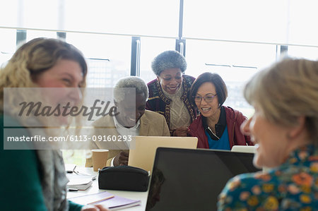 Senior business people working at laptop in conference room meeting