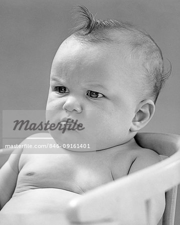 1940s PORTRAIT BABY FROWNING SCOWLING SITTING IN CHAIR