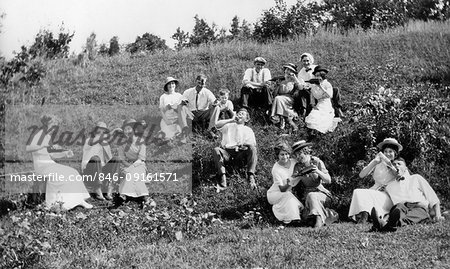 1890s 1900s TURN OF THE 20TH CENTURY GROUP OF COUPLES MEN & WOMEN DRINKING MANY BOTTLES OF ADULT BEVERAGES SITTING ON HILLSIDE