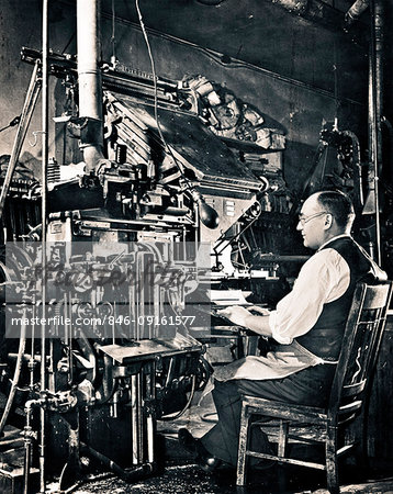 1930s ANONYMOUS MAN SEATED AT COMPOSING KEYBOARD OF LINOTYPE HOT METAL TYPESETTING MACHINE