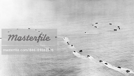 1940s WWII AERIAL VIEW CIRCLING NAVY HIGGINS BOATS MARCH 1944 OFF OF EMIRAU ISLAND IN PACIFIC OCEAN PRIOR TO LANDING OPERATION