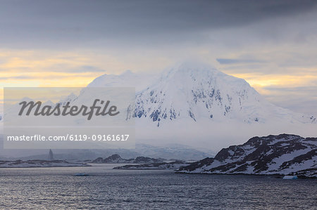 Misty Mount William at sunrise, rising from tidewater glaciers, Anvers Island, Antarctic Peninsula, Antarctica, Polar Regions