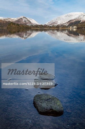 Stones in shallow water and perfect reflection of snow covered mountains and sky in the still waters of Grasmere, Lake District National Park, UNESCO World Heritage Site, Cumbria, England, United Kingdom, Europe