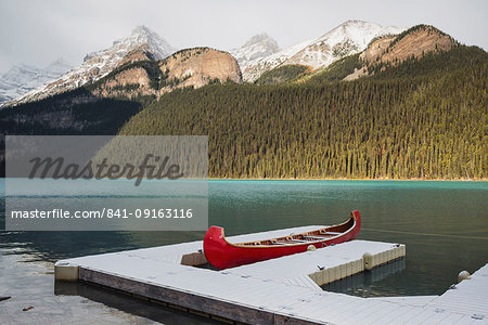 Red canoe and dock in Lake Louise with snow-covered mountains, Banff National Park, UNESCO World Heritage Site, Alberta, The Rockies, Canada, North America