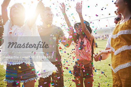 Five young adult friends throwing confetti at Holi Festival