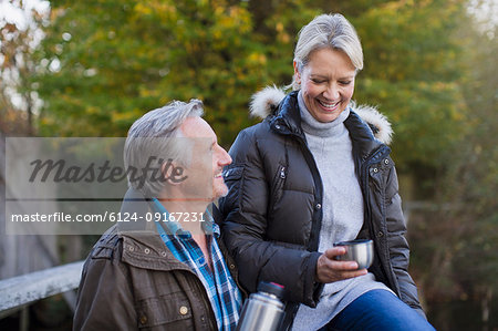 Mature couple drinking coffee in park