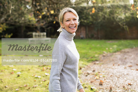 Portrait smiling, confident mature woman in sunny autumn backyard