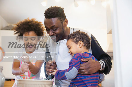 Father and toddler children baking in kitchen