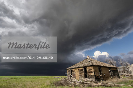 Intense sunshine and severe thunderstorm, barn in foreground, Cope, Colorado, US