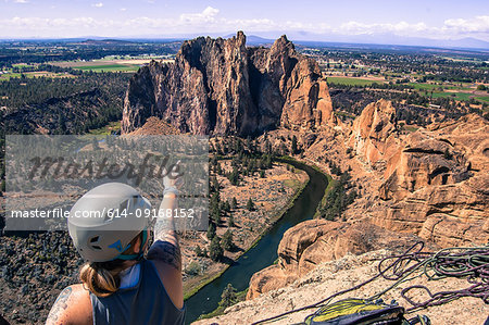 Rock climber pointing at rock formation, Smith Rock State Park, Terrebonne, Oregon, United States