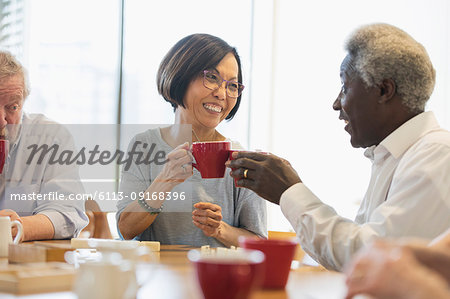 Happy senior friends enjoying tea in community center