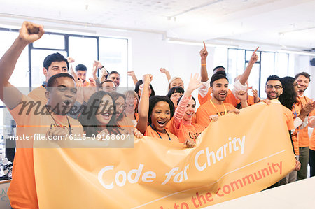 Portrait enthusiastic hackers cheering with banner, coding for charity at hackathon