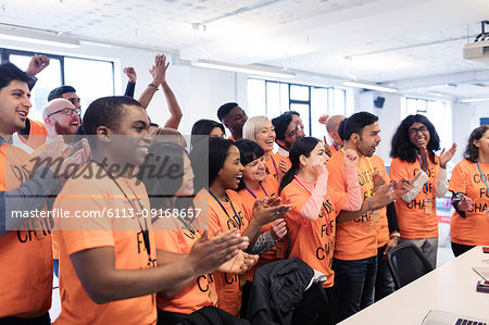 Happy hackers cheering and celebrating, coding for charity at hackathon