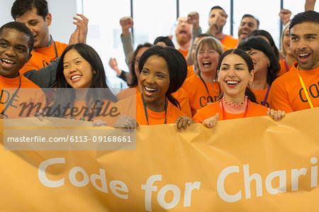 Happy hackers with banner coding for charity at hackathon