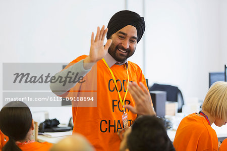 Happy hackers high-fiving, coding for charity at hackathon