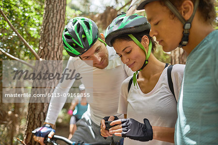 Friends mountain biking, checking wearable camera