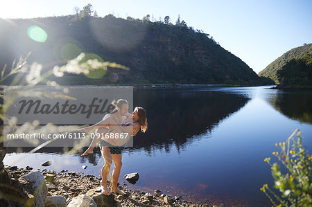 Romantic, carefree couple at sunny summer lake