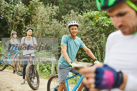 Friends mountain biking, resting on trail