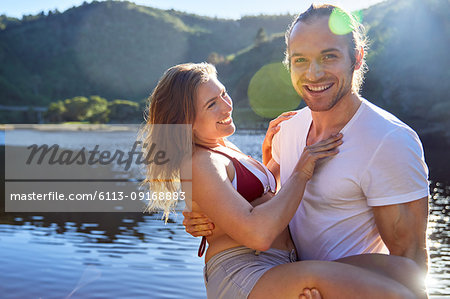Portrait romantic, carefree couple at sunny summer lake