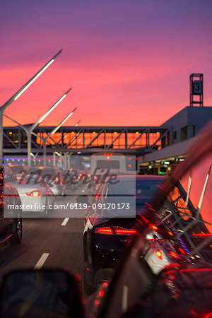 Traffic going into Los Angeles airport under a vibrant orange and pink sunset, California, United States of America, North America