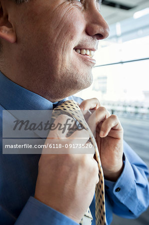 Closeup of a businessman tying his business tie.