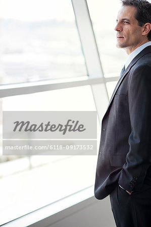 Closeup of a Caucasian businessman looking out the widow of a conference centre lobby.