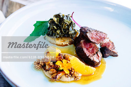 Beef tenderloin with chanterelle mushrooms, mandarin oranges, peanuts, collard greens, and grits