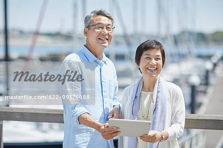 Japanese senior couple having fun by the sea