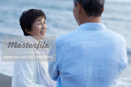 Japanese senior couple having fun by the sea