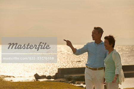 Japanese senior couple having fun by the sea