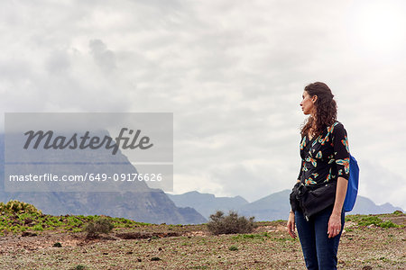 Woman looking out toward low cloud over mountains, Las Palmas, Gran Canaria, Canary Islands, Spain