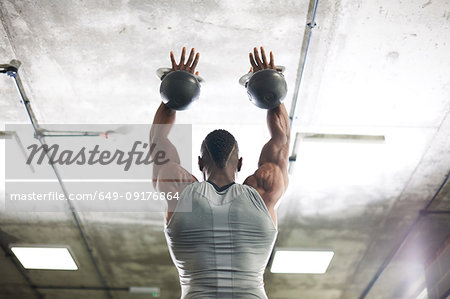 Man lifting kettlebells in gym