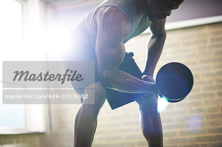 Man lifting dumbbell in gym