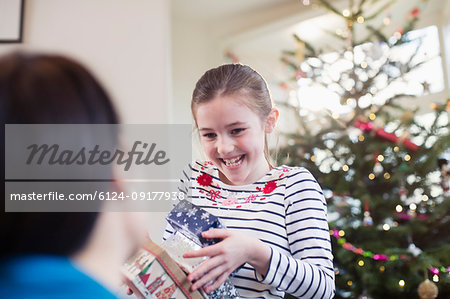 Happy, eager girl gathering Christmas gifts