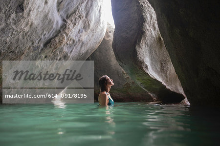 Young woman exploring flooded grotto, Virgin Gorda, British Virgin Islands