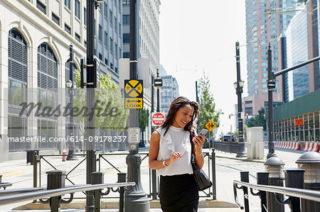 Businesswoman using cellphone by barriers