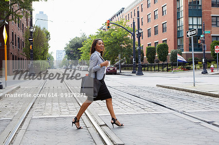 Businesswoman crossing light rail tracks