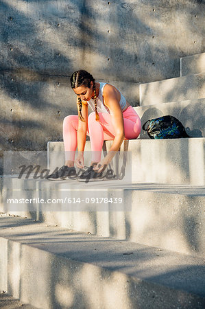Woman tying trainer laces on steps