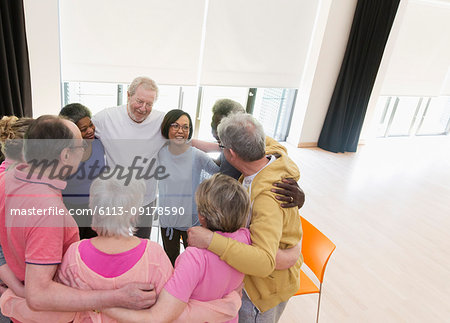Active seniors hugging in circle