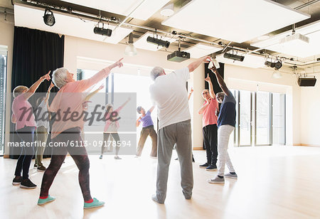 Active seniors dancing, exercising and stretching in circle
