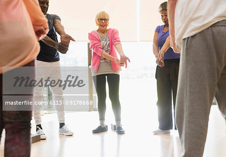 Active seniors stretching wrists in exercise class
