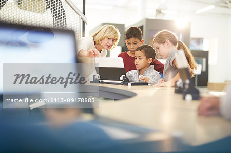 Teacher and students using laptop